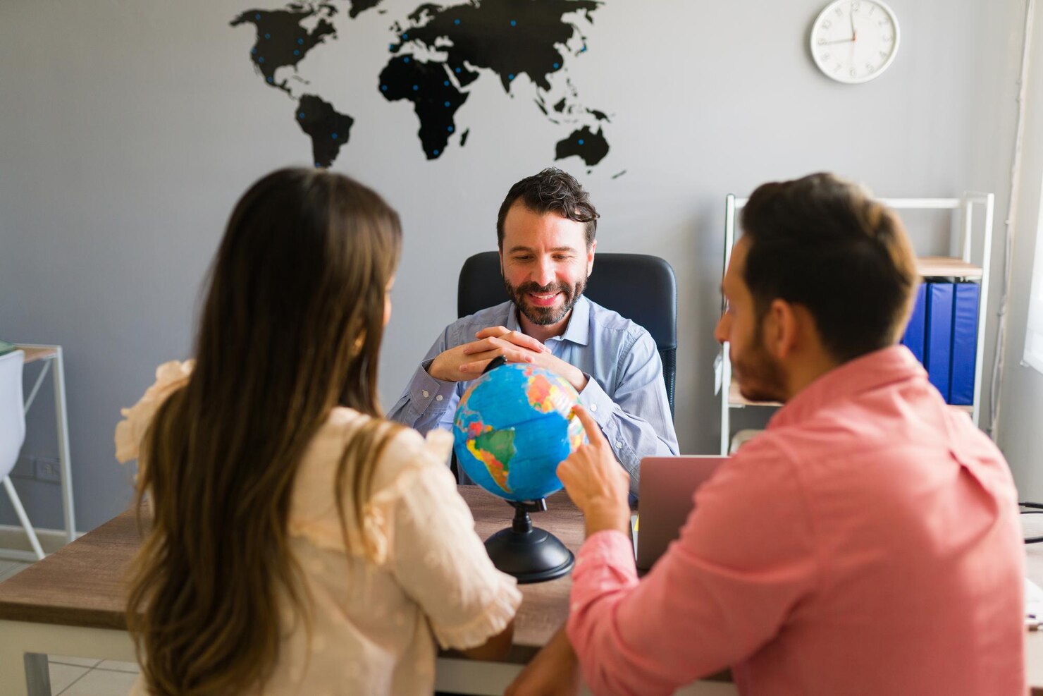 rear-view-hispanic-young-woman-man-looking-countries-globe-while-planning-their-trip-abroad-with-travel-agent_662251-2206